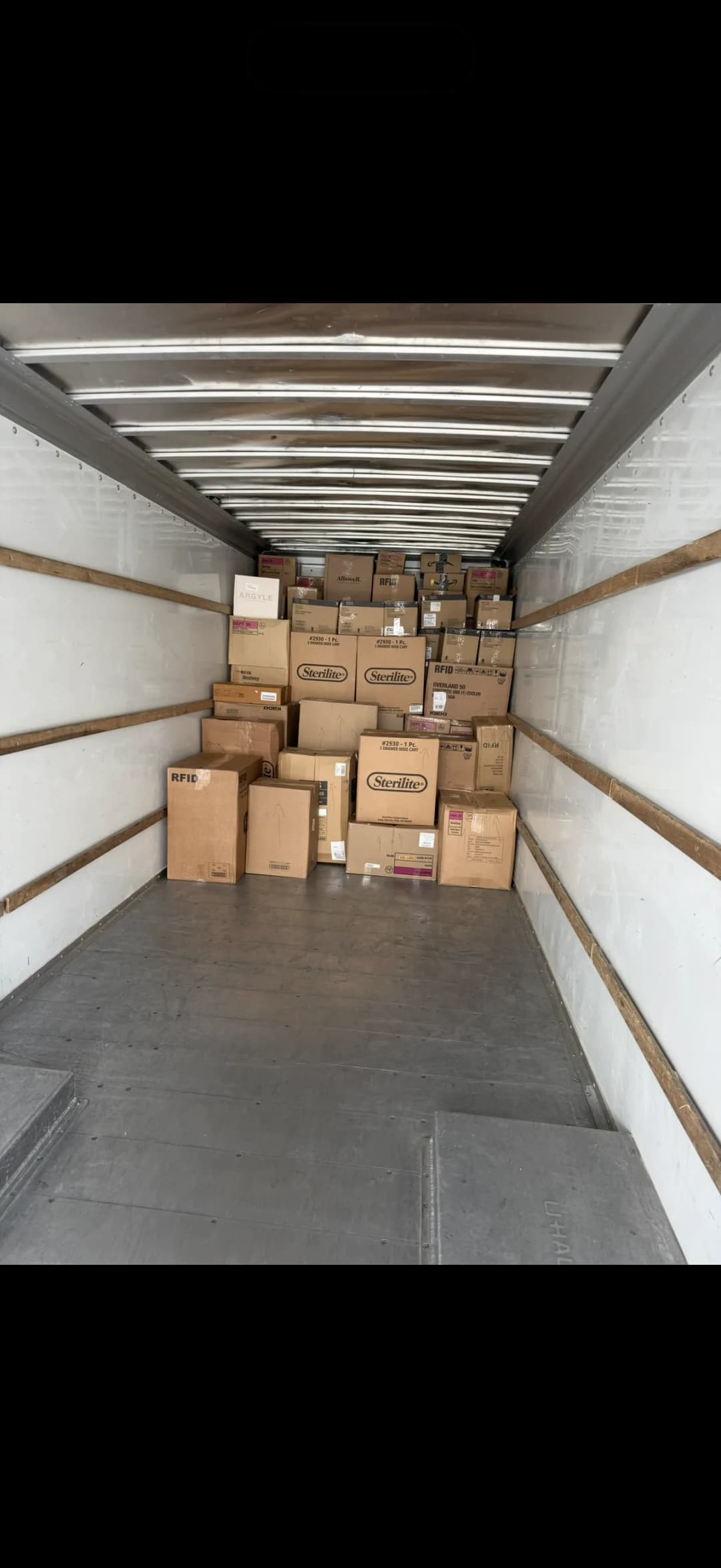 Packed moving truck with labeled boxes secured inside